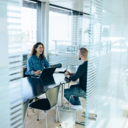 Imagen de una trabajadora atendiendo a un cliente ofertando los servicios financieros disponibles de Banco Sabadell.